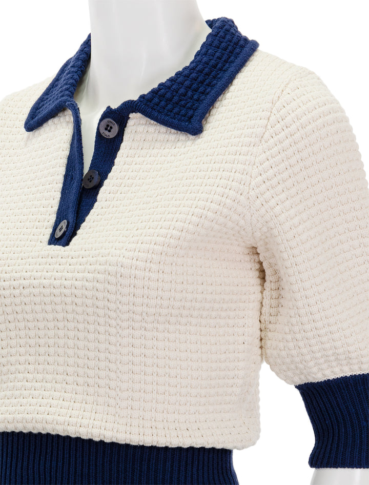 Close-up view of Staud's altea sweater in ivory and navy.