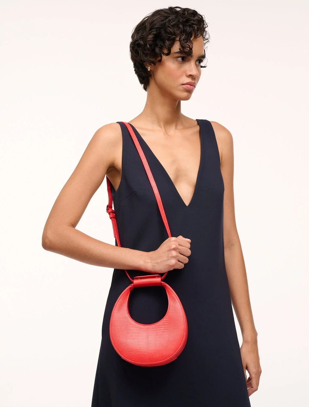 Model wearing STAUD's good night moon bag in red rose on her shoulder.