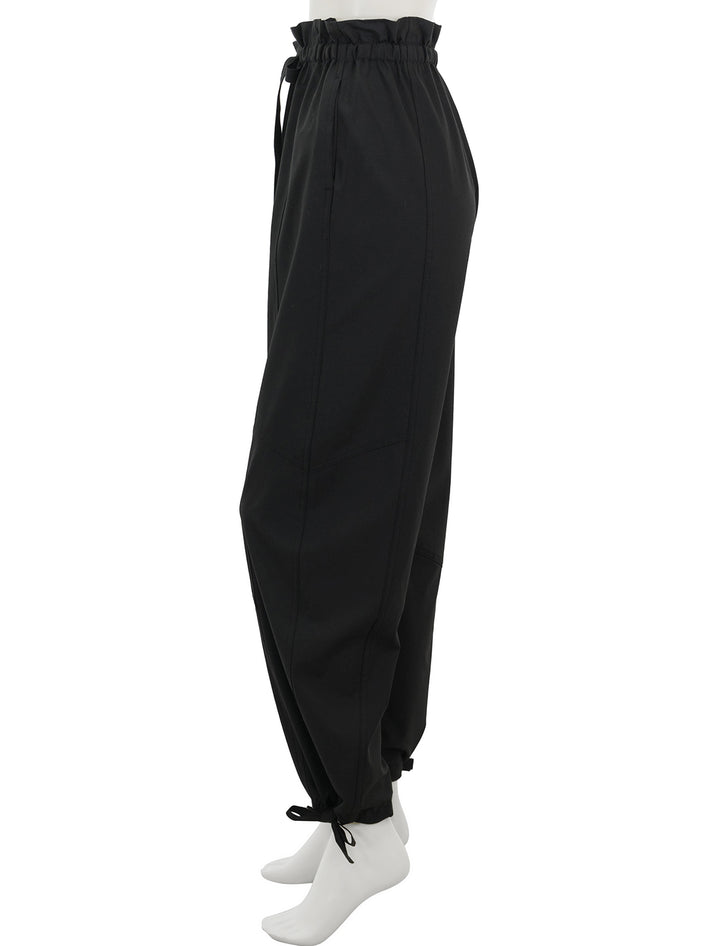 Side view of GANNI's drapey melange pants in black.