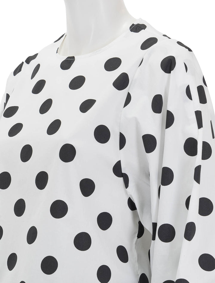 Close-up view of Essentiel Antwerp's fake balloon sleeve top in bright sky polka dot.