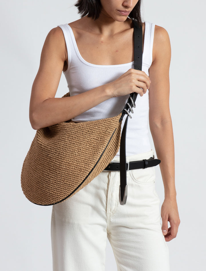 Model wearing Rag & Bone's spire hobo in straw.