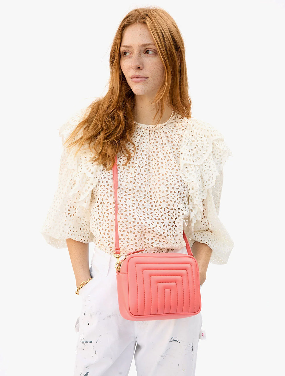 Model wearing Clare V.'s midi sac in bright coral.