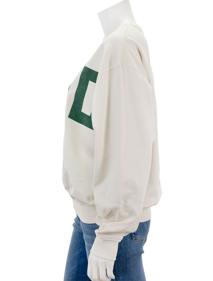 Side view of Clare V.'s ciao oversized sweatshirt in cream and evergreen.