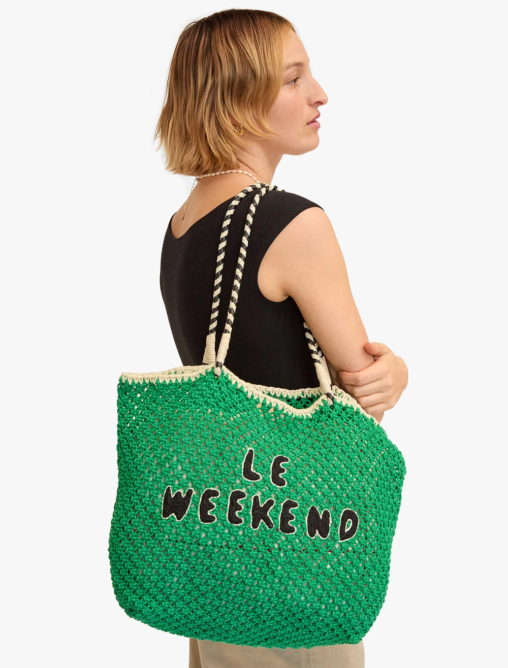 Model wearing Clare V.'s lete tote | green crochet le weekend on her shoulder.