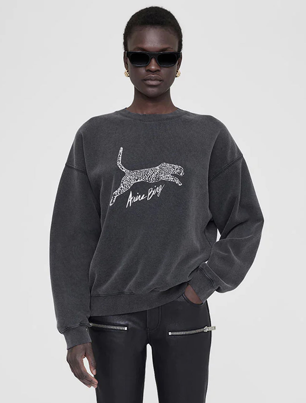 Model wearing Anine Bing's spotted leopard spencer sweatshirt in washed black.