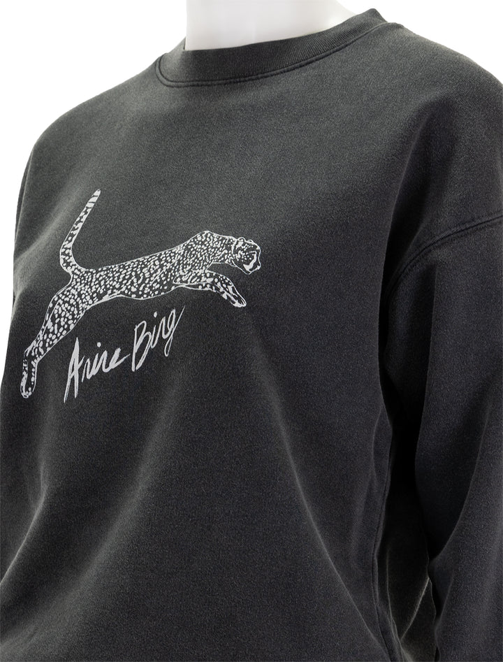 Close-up view of Anine Bing's spotted leopard spencer sweatshirt in washed black.