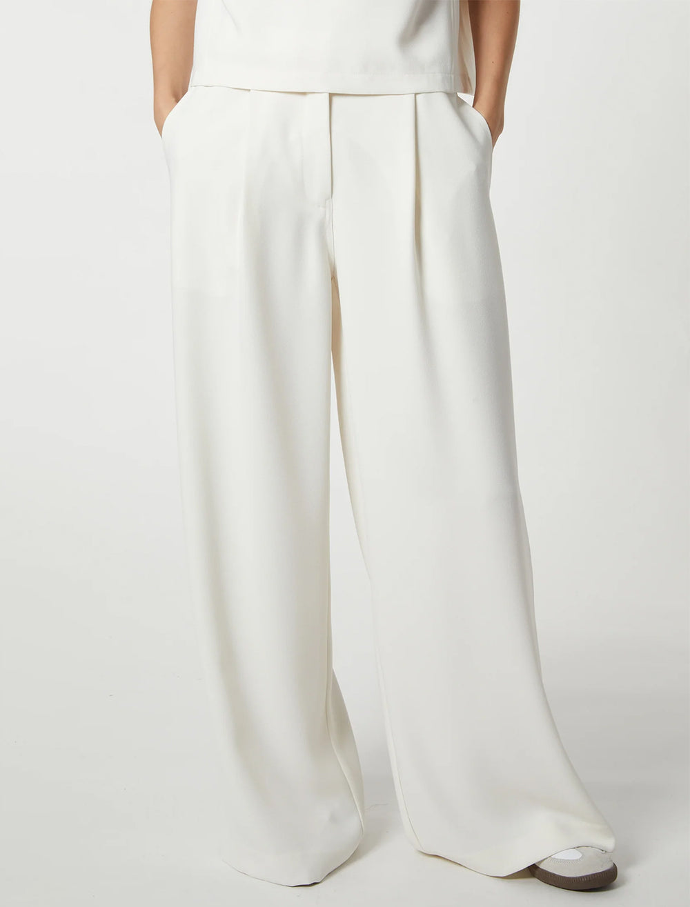 Model wearing Saint Art's neve mid waisted wideleg trouser in ivory crepe.