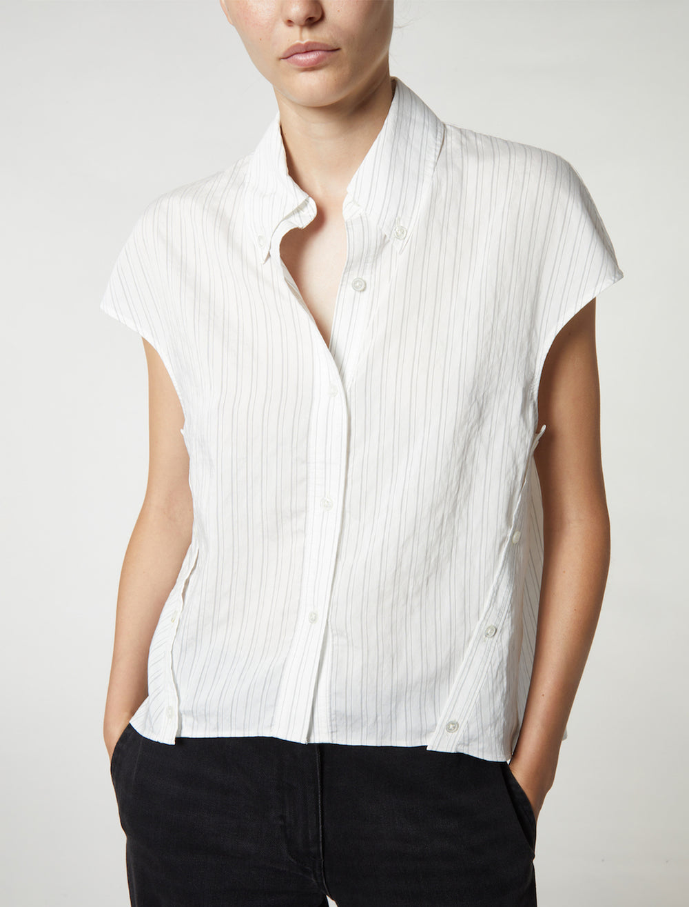 Model wearing Saint Art's perth cap sleeve button blouse in off white pinstripe.