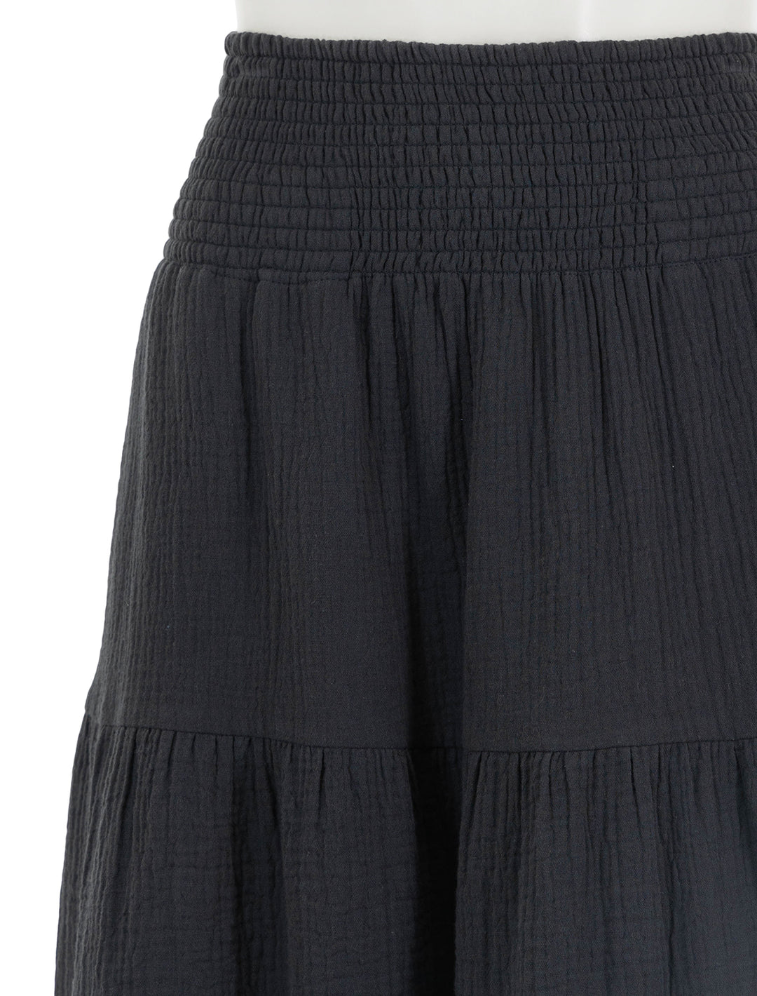 Close-up view of marine layer's corinne smocked waist maxi skirt in black.