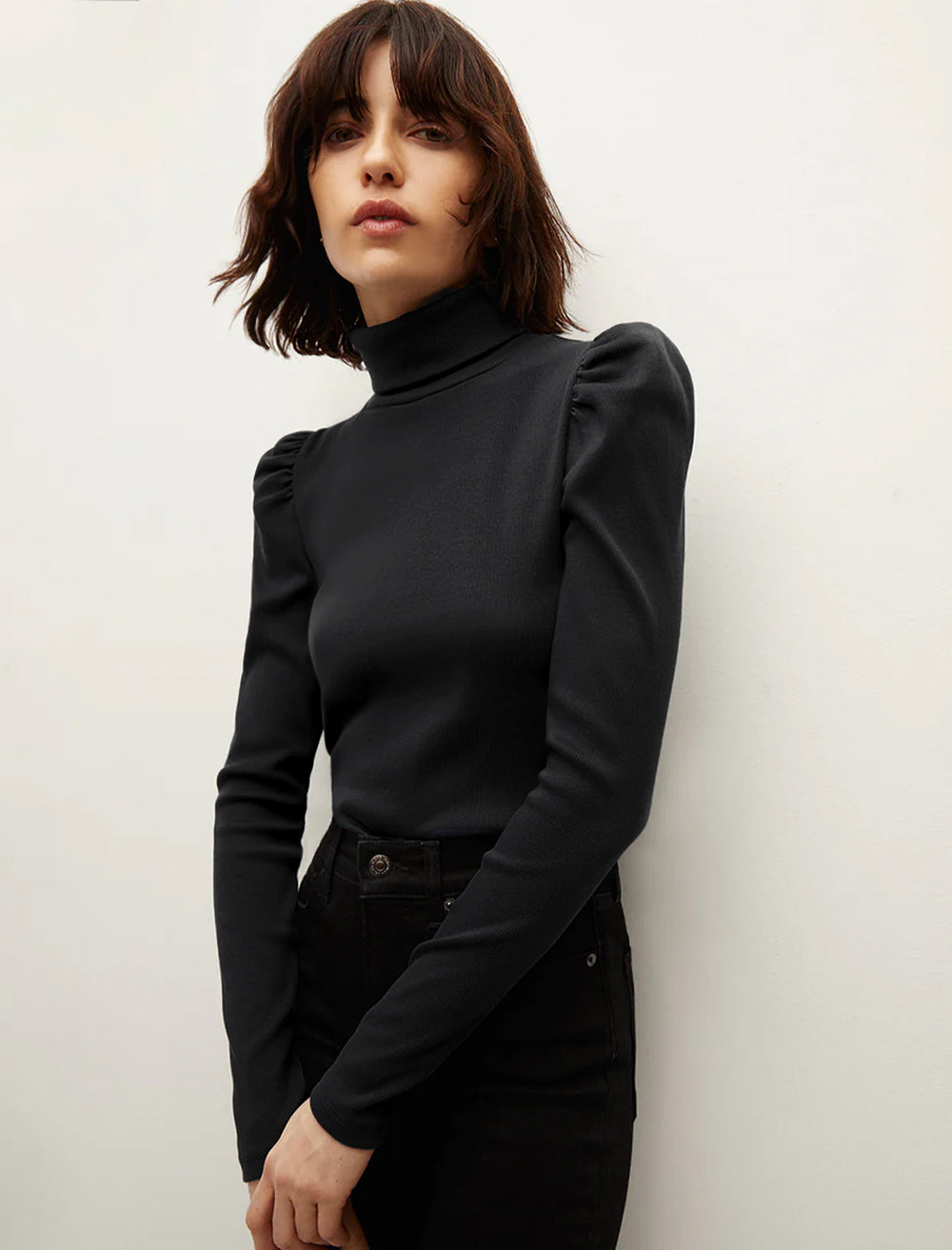 Model wearing Veronica Beard's cedar turtleneck in solid black.