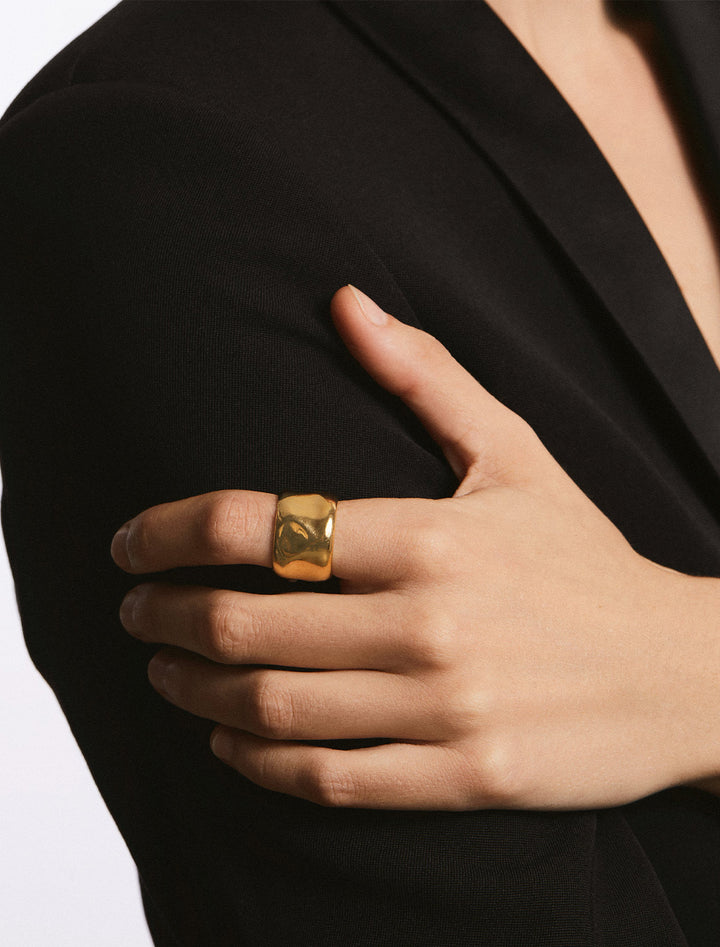 Model wearing Anna Beck's large wavy cigar ring in gold.