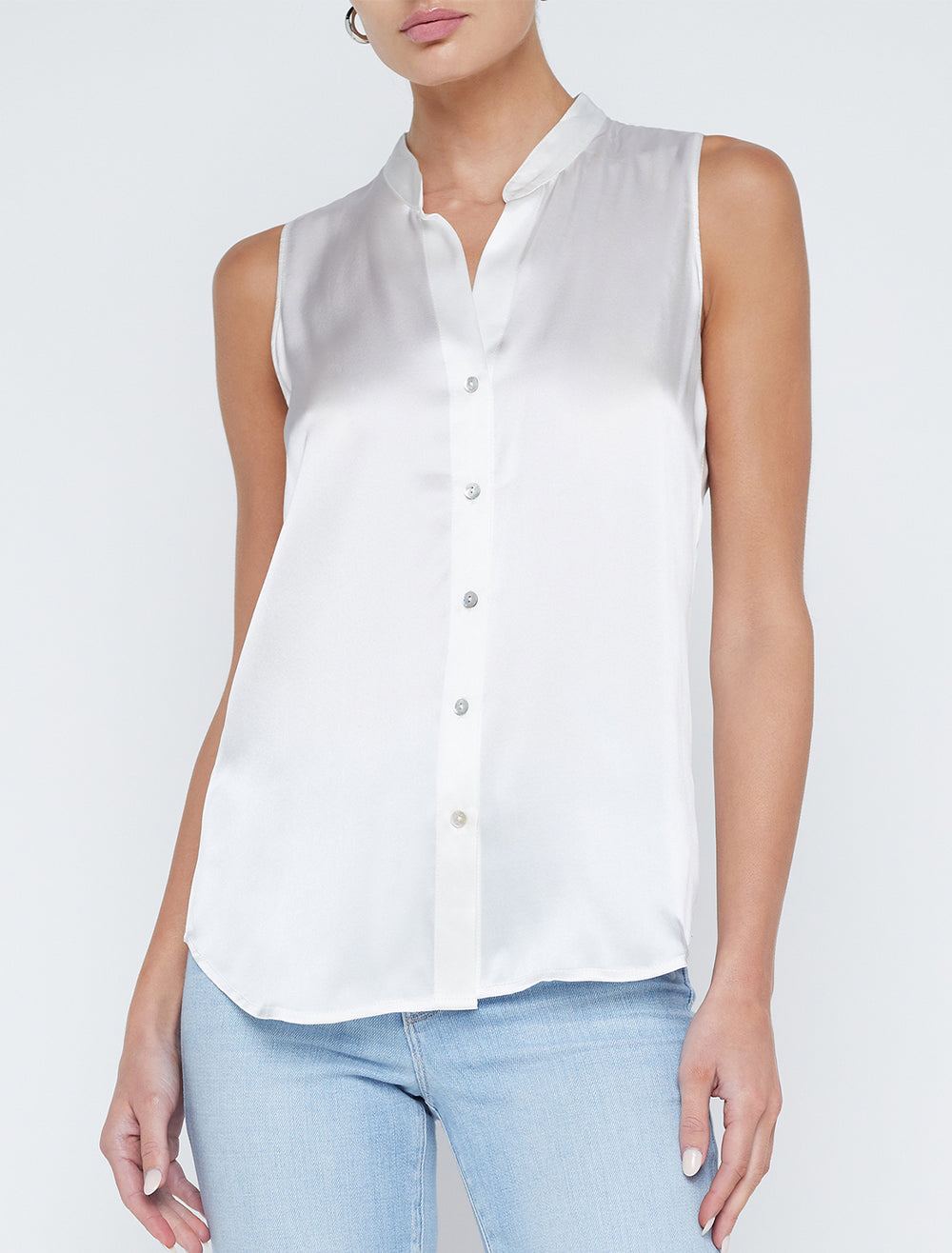 Model wearing L'agence's hendrix band collar sleeveless blouse in white.