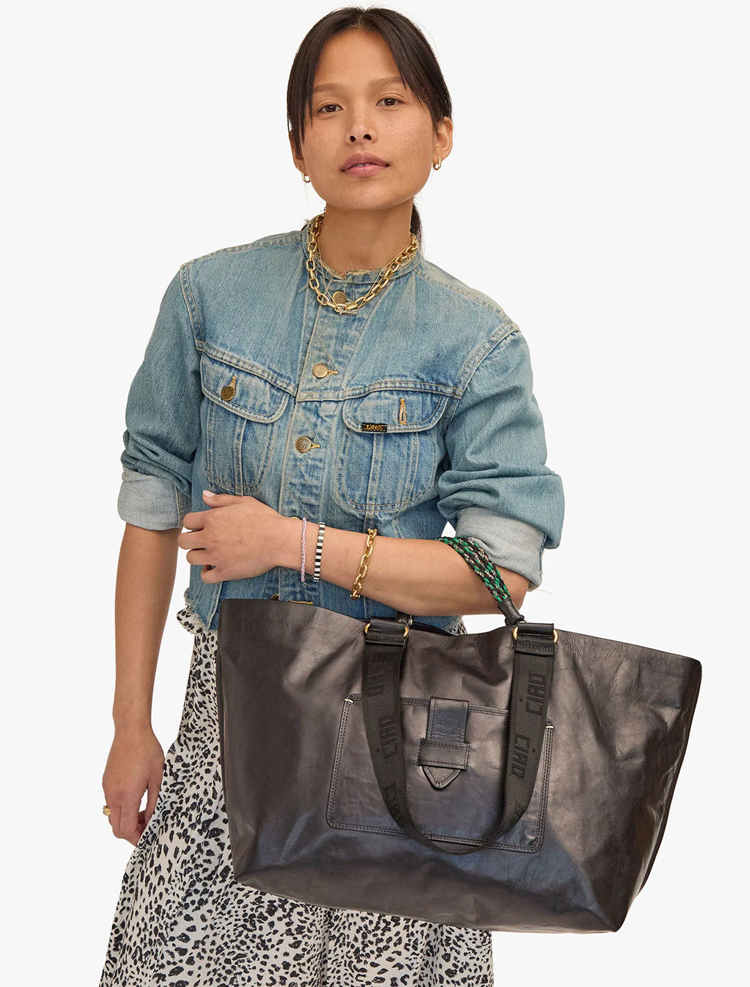 Model holding Clare V.'s grande bateau tote in black new look.