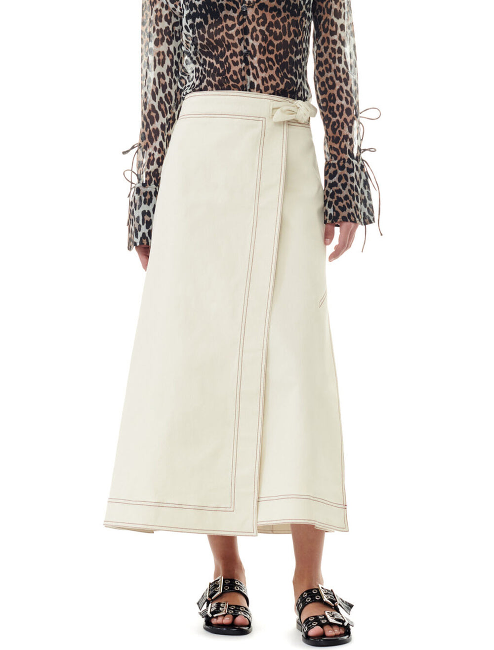 Model wearing GANNI's herringbone canvas long wrap skirt in summer sand.