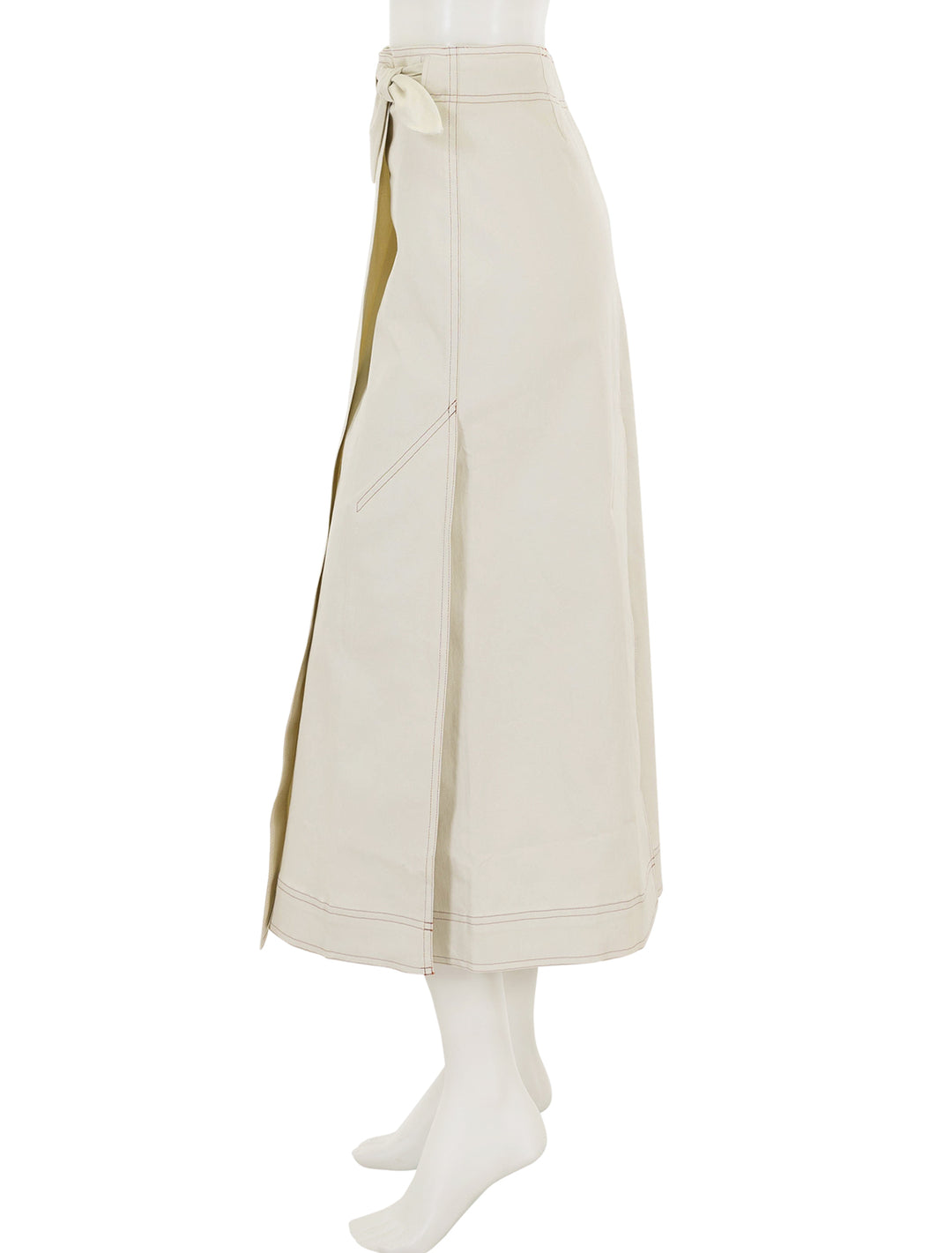 Side view of GANNI's herringbone canvas long wrap skirt in summer sand.