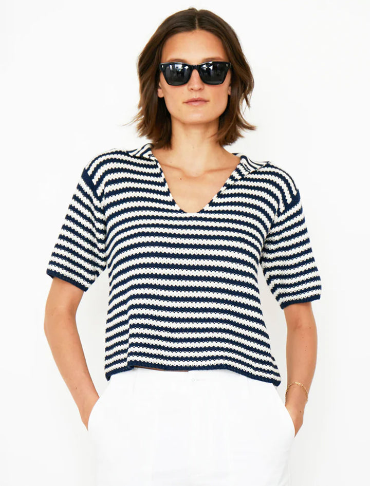 Model wearing KULE's the lucie knit polo in cream and navy stripe.