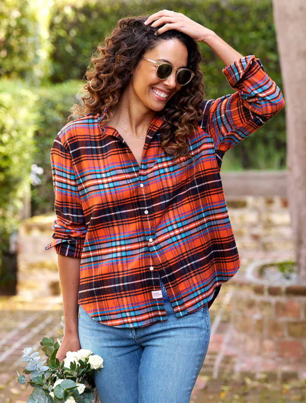 Model wearing Frank & Eileen's eileen in orange, blue and black plaid flannel.