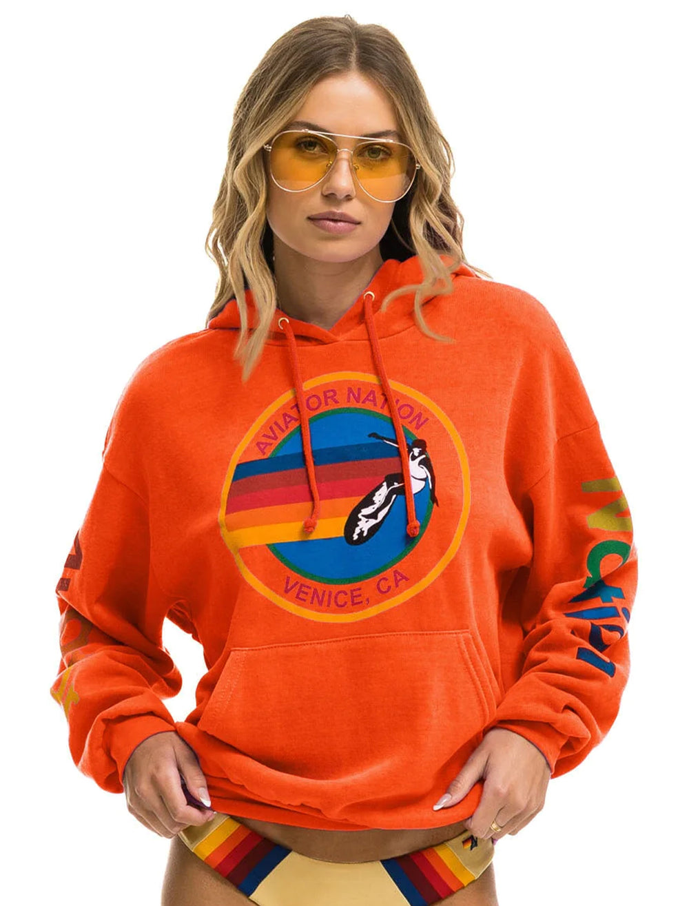 Model wearing Aviator Nation's aviator nation pullover hoodie in orange.