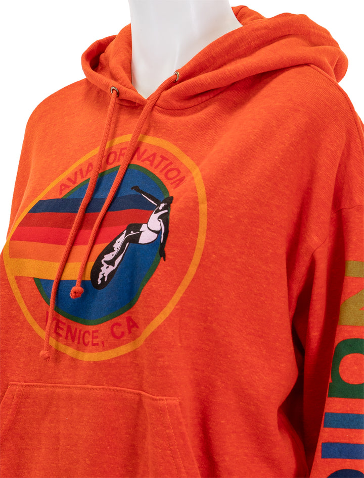 Close-up view of Aviator Nation's aviator nation pullover hoodie in orange.