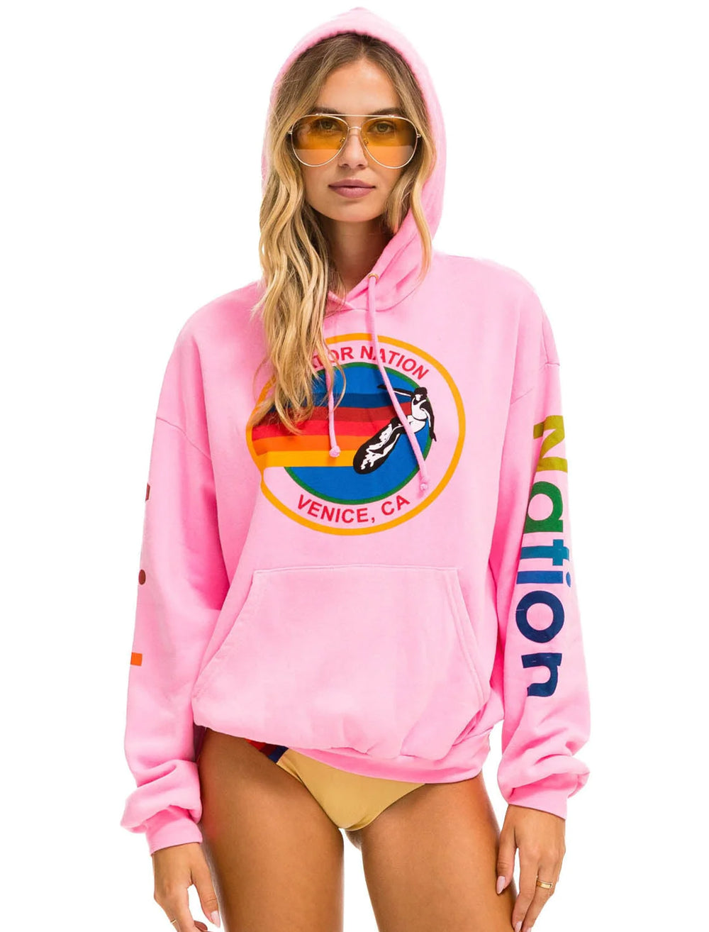 Model wearing Aviator Nation's pullover hoodie relaxed in neon pink.
