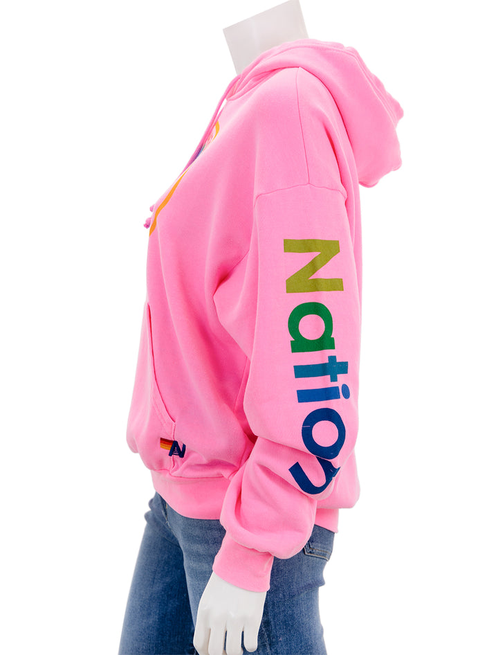 Side view of Aviator Nation's pullover hoodie relaxed in neon pink.