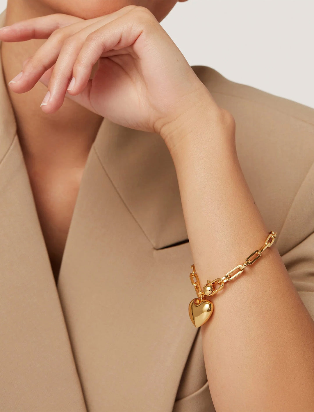 Model wearing Jenny Bird's puffy heart chain bracelt in gold.