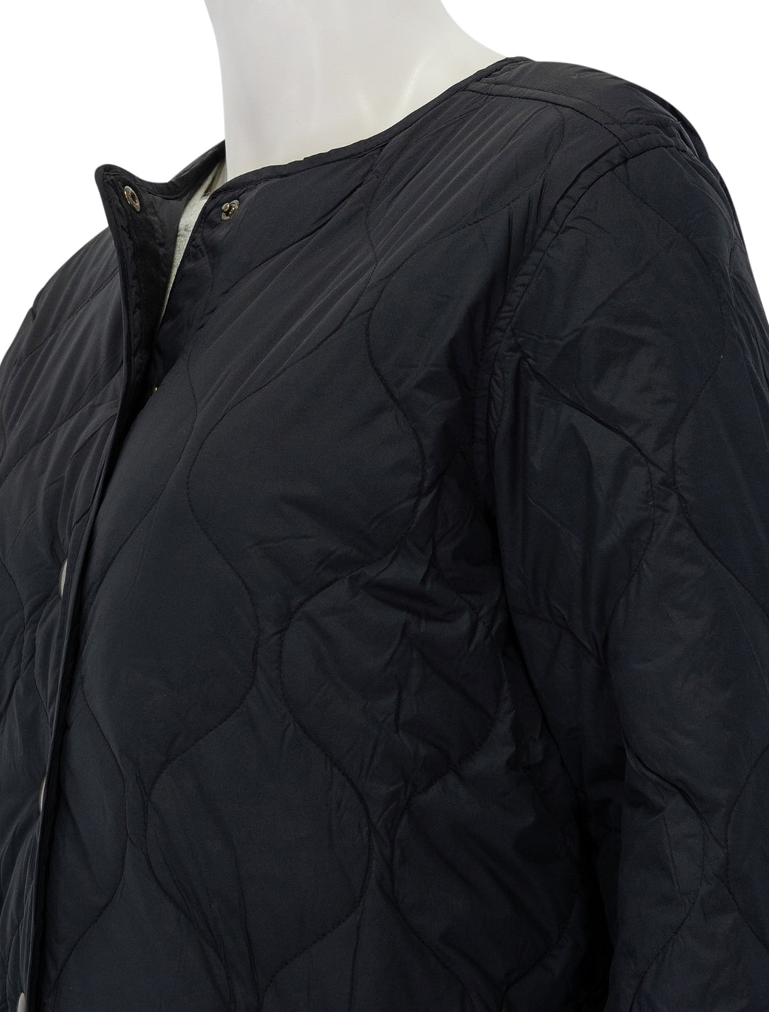 Close-up view of Marine Layer's mid length quilted coat in black.