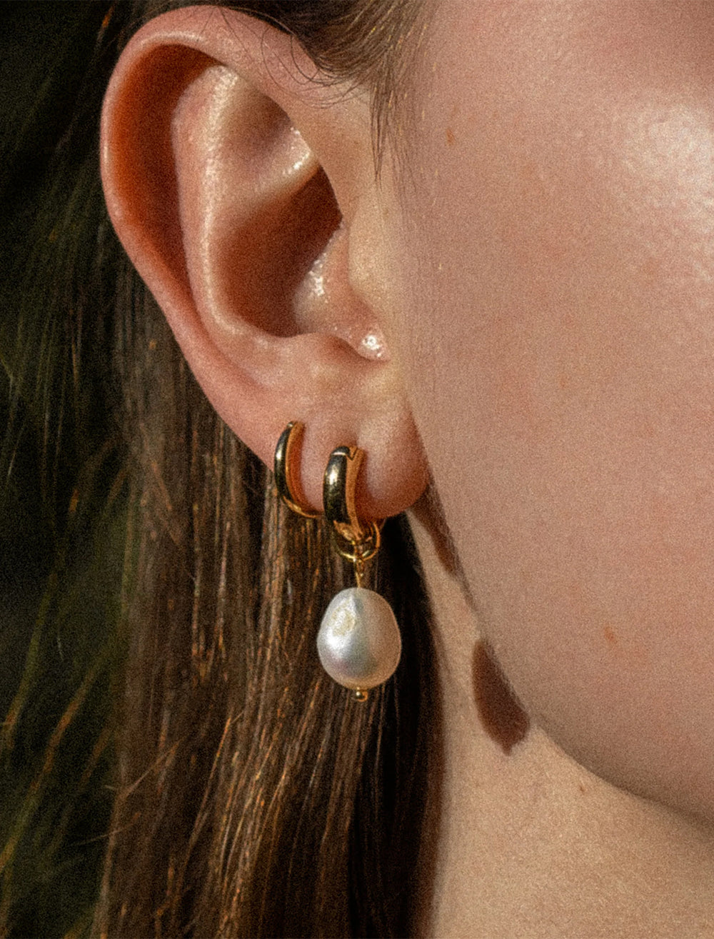 Model wearing THATCH's petite colette pearl earrings in gold.