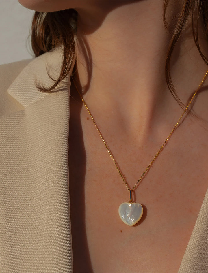 Model wearing THATCH's gemma mother of pearl heart necklace in gold.