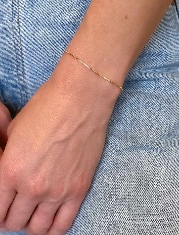 Model wearing THATCH's solange box chain bracelet in gold.
