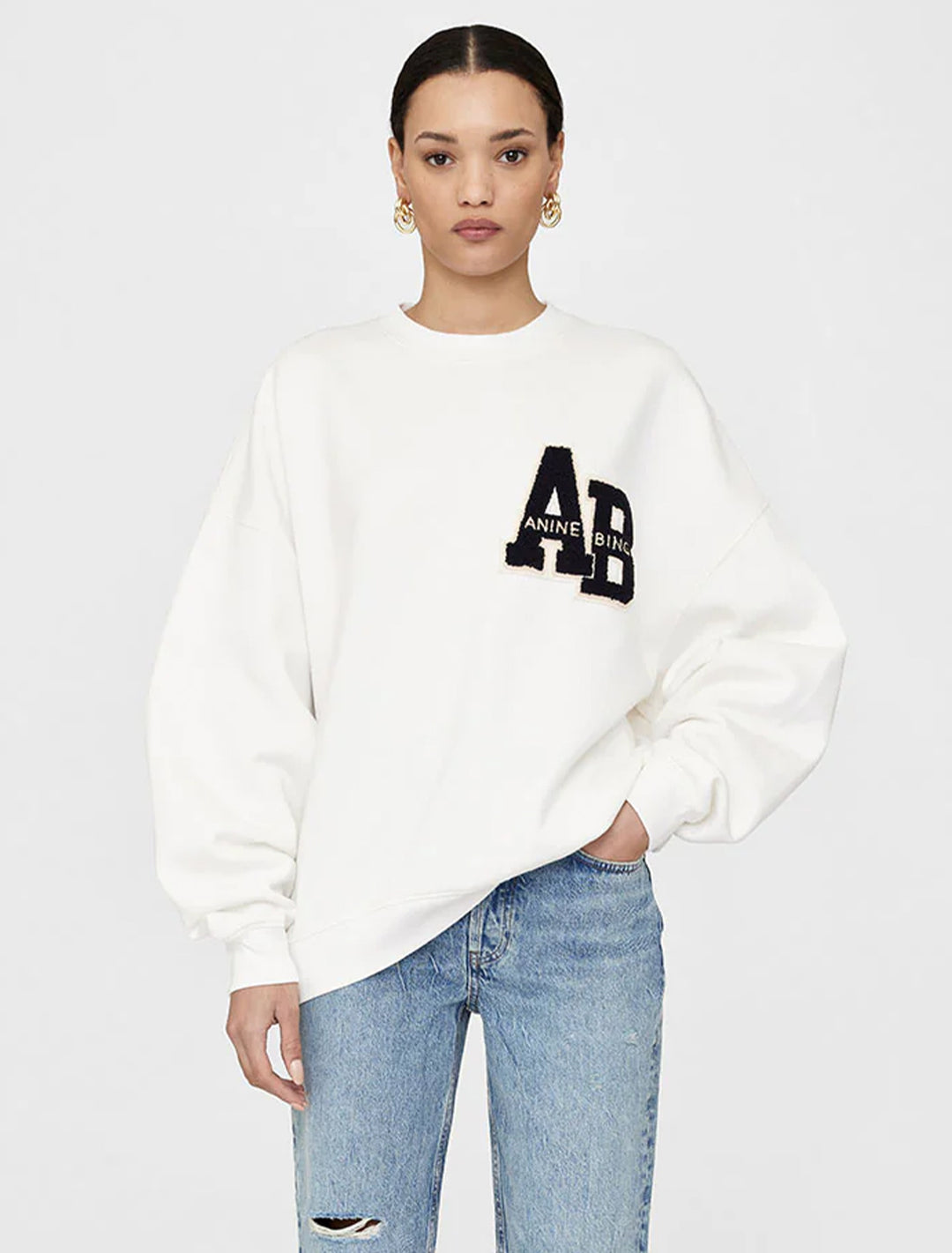 Model wearing Anine Bing's miles letterman sweatshirt in off white.