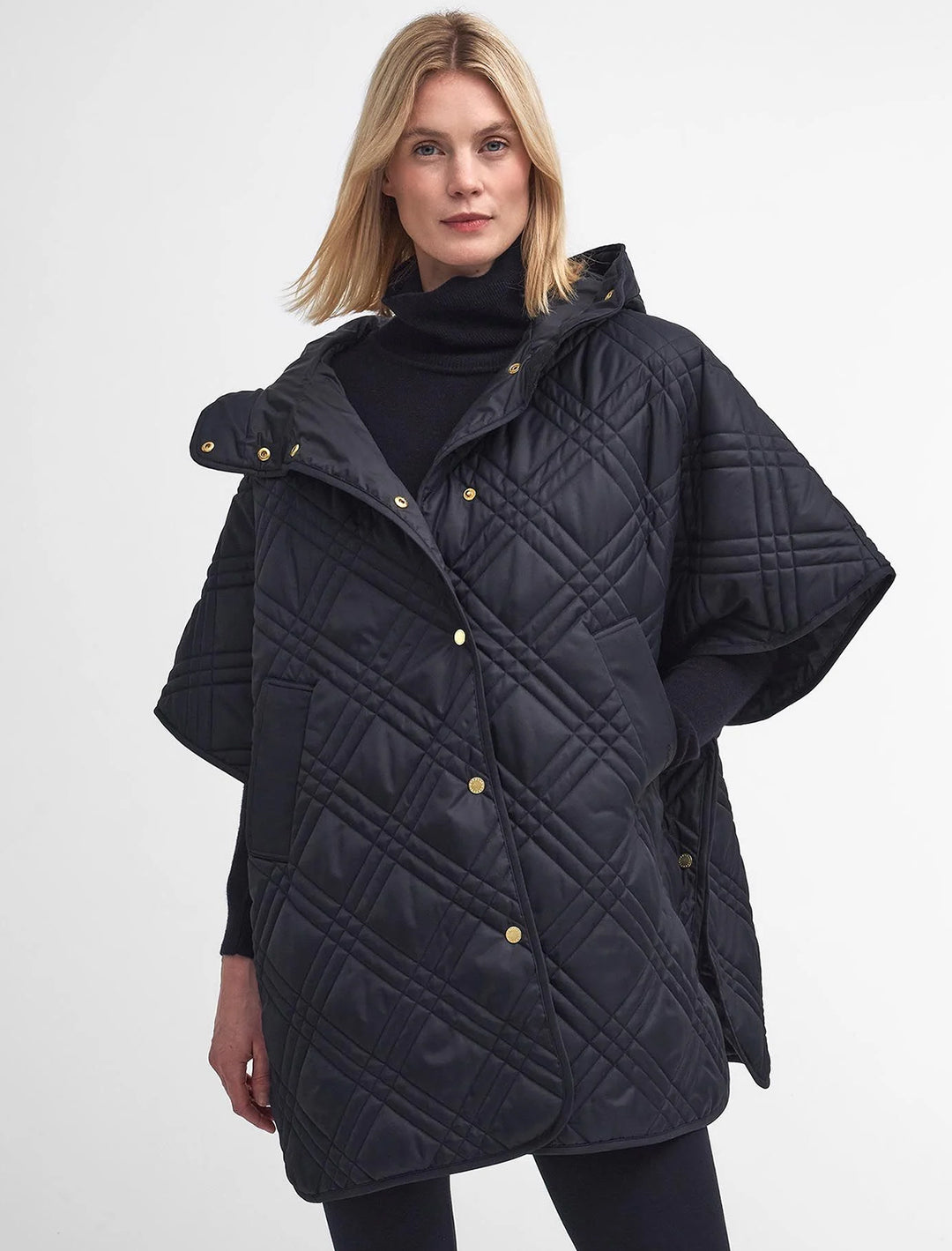 Model wearing Barbour's astor quilted cape in black.