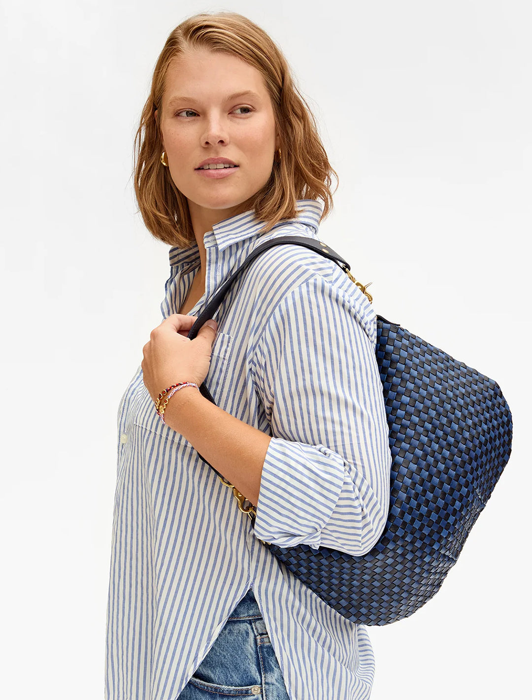 Model wearing Clare V.'s moyen messenger in dark blue woven on her shoulder.