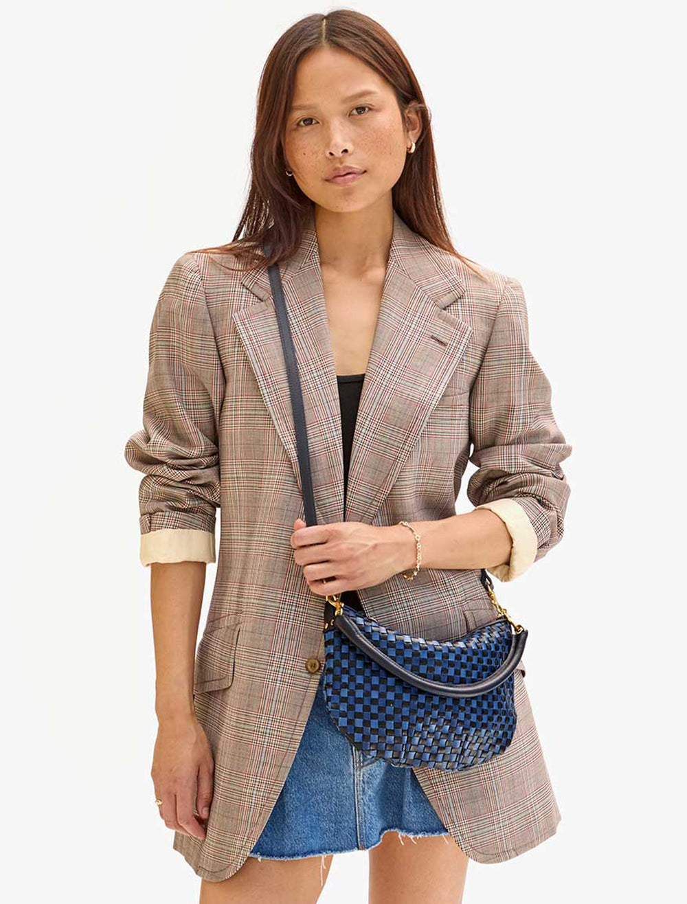 Model wearing Clare V.'s petite moyen messenger in dark blue woven.