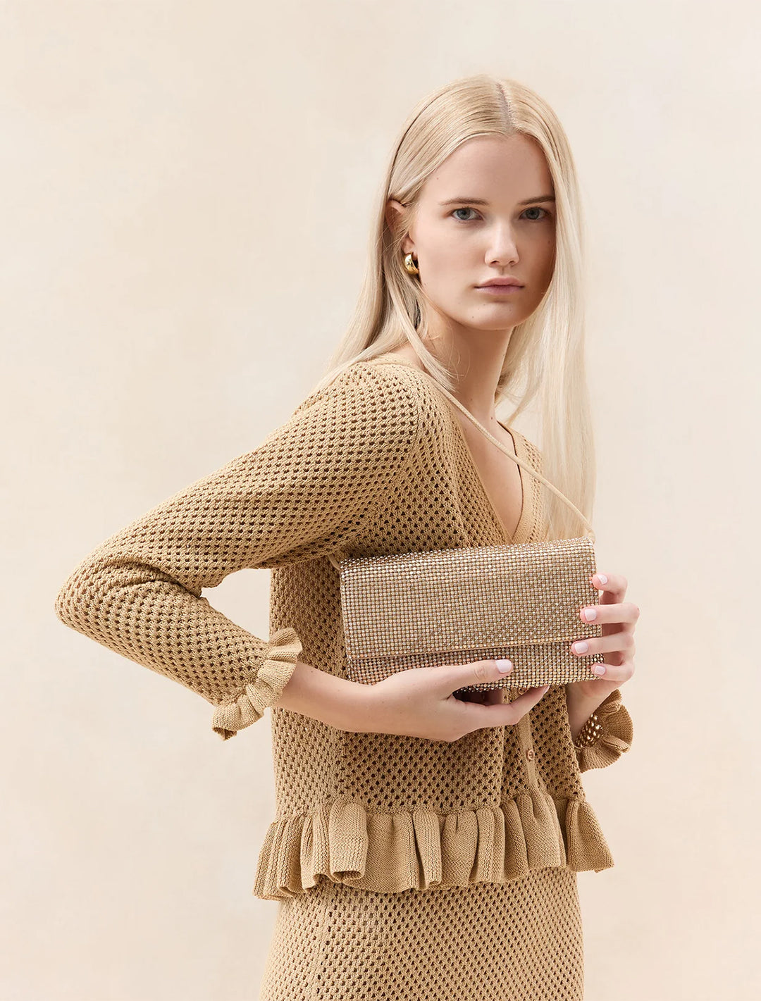 model holding charlee clutch in gold crystal