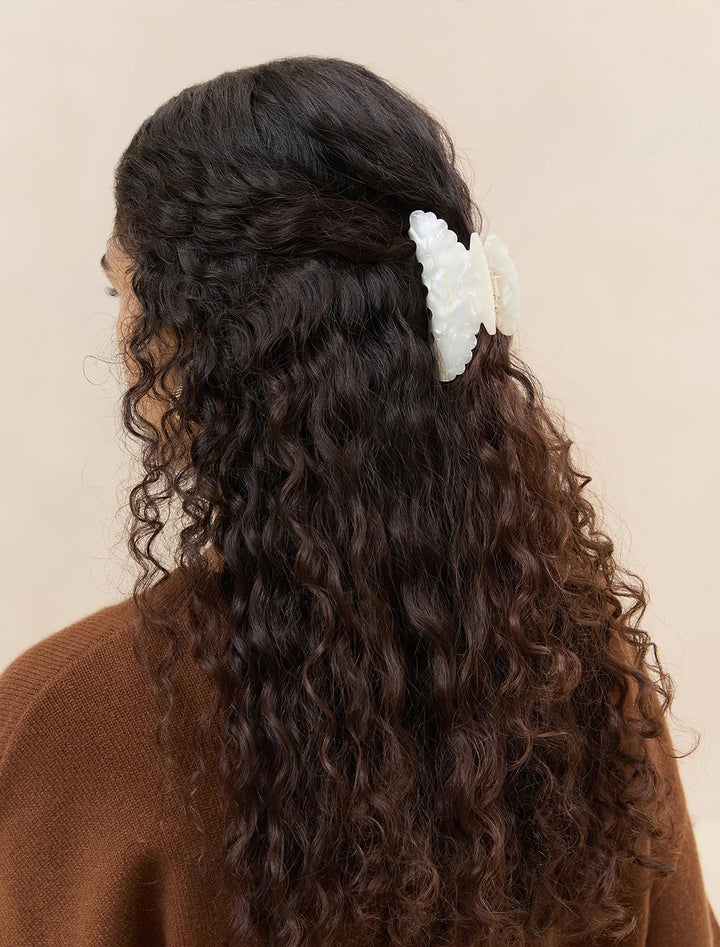 Model wearing Loeffler Randall's lila pearl hair accessories set, specifically the claw clip.