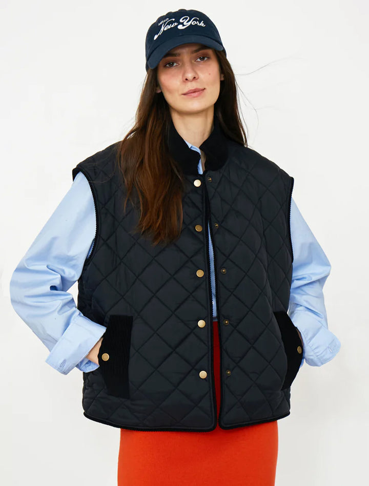 Model wearing KULE's the rupert quilted vest in black.