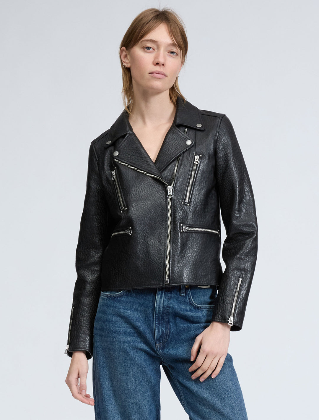 Model wearing Rag & Bone's arrow leather jacket in black.