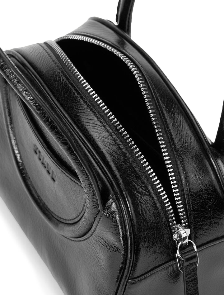 Close-up inside view of Staud's maude mini bowler bag in black.