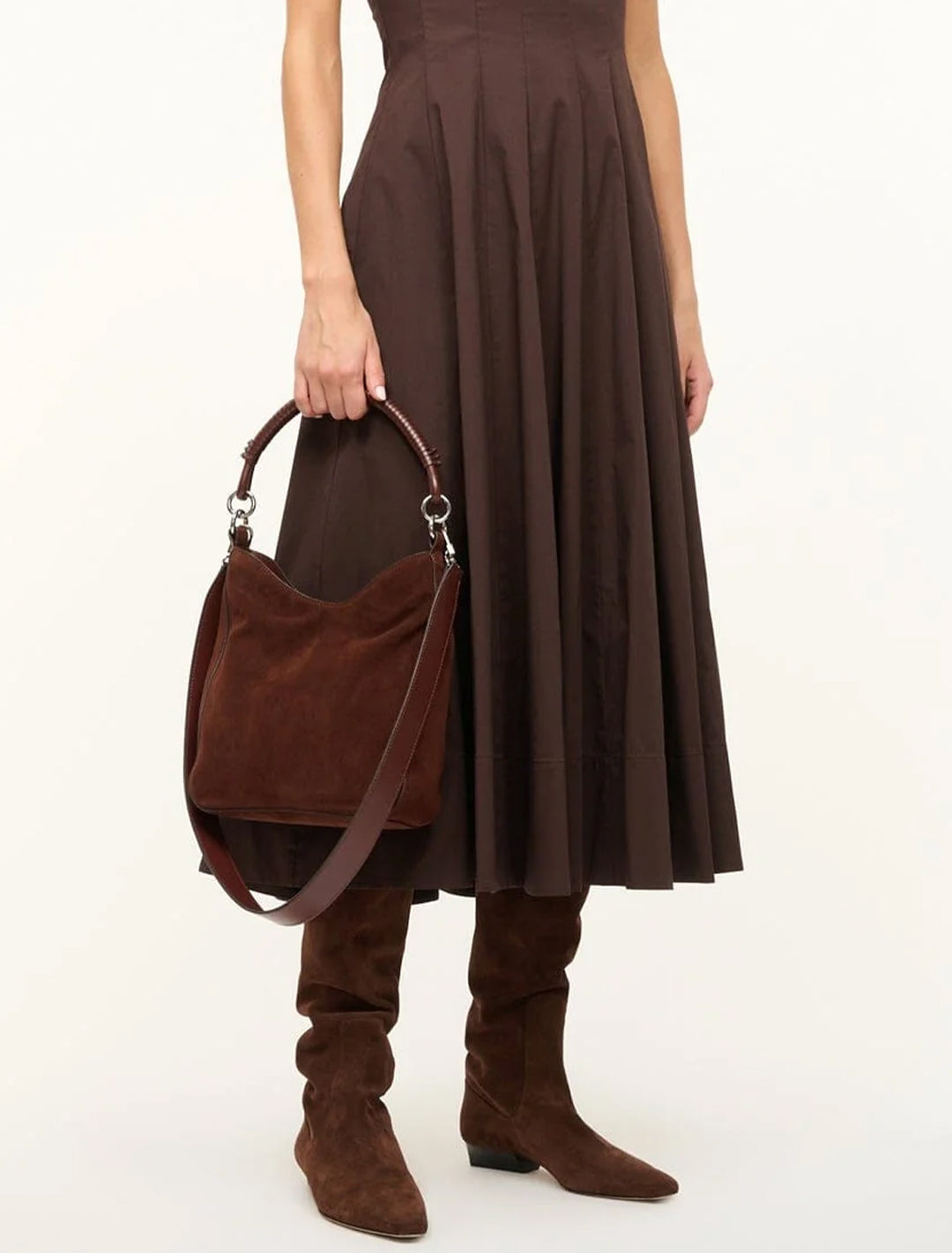 Model carrying Staud's mel shoulder bag in mahogany suede.