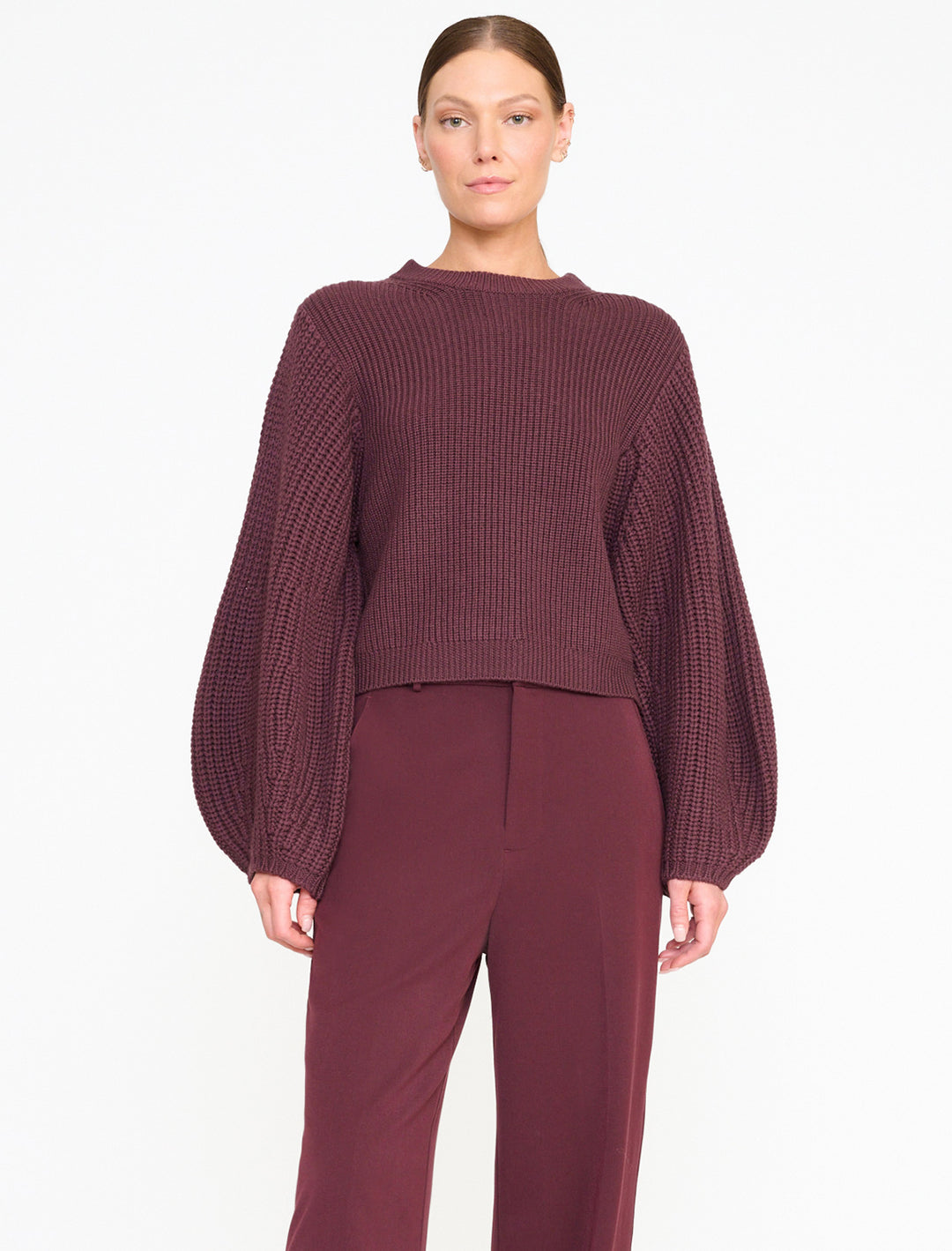 Model wearing STAUD's aura sweater in merlot.