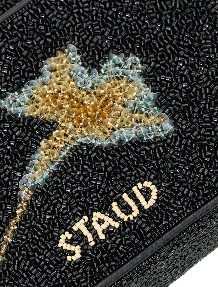 Close-up view of Staud's tommy bag in botanical shadows.