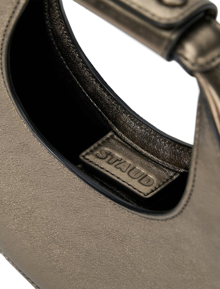 Close-up view of Staud's good night moon bag in aged bronze.