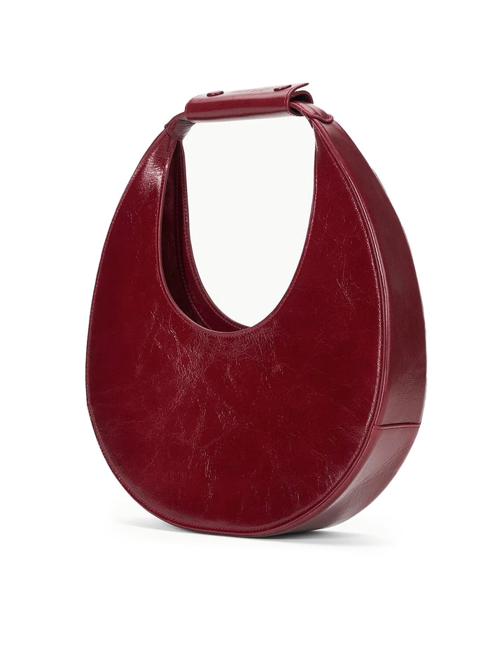 Side angle view of Staud's moon tote bag in pinot.