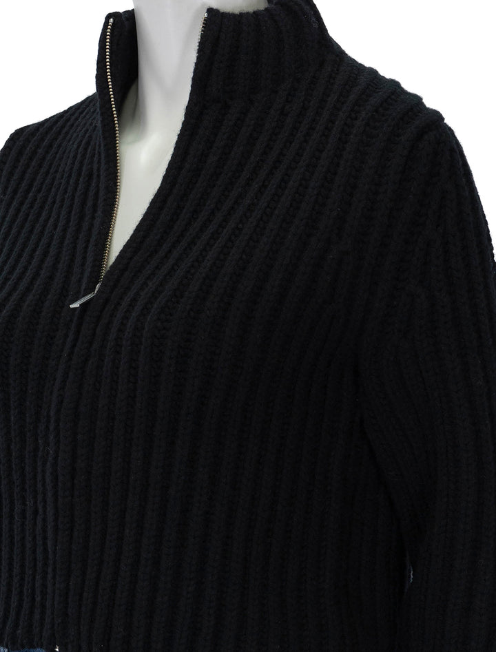 Close-up view of Theory's zip up cardigan in black.