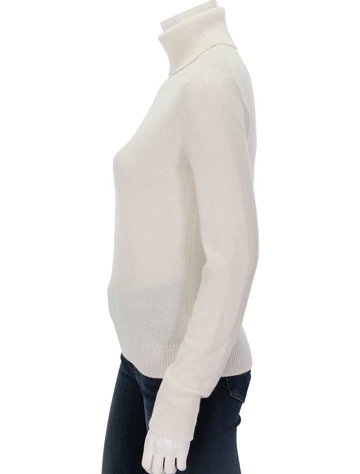 Side view of Theory's classic cashmere turtleneck in ivory.