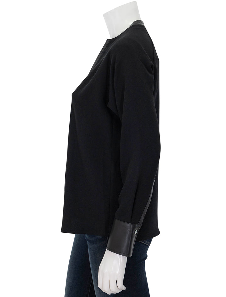 Side view of Vince's leather trim dolman sleeve blouse.