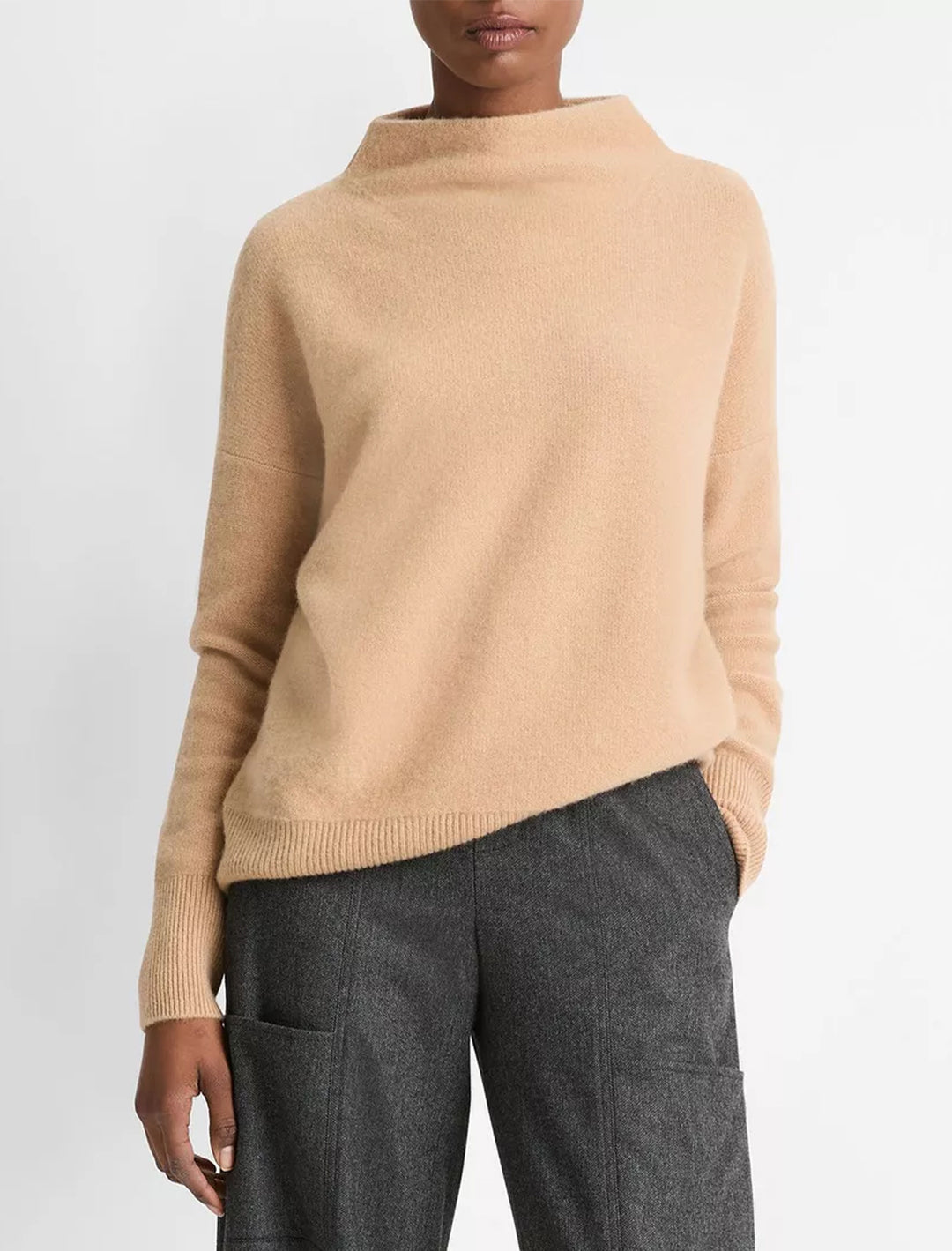 Model wearing Vince's boiled funnel neck pullover in camel.