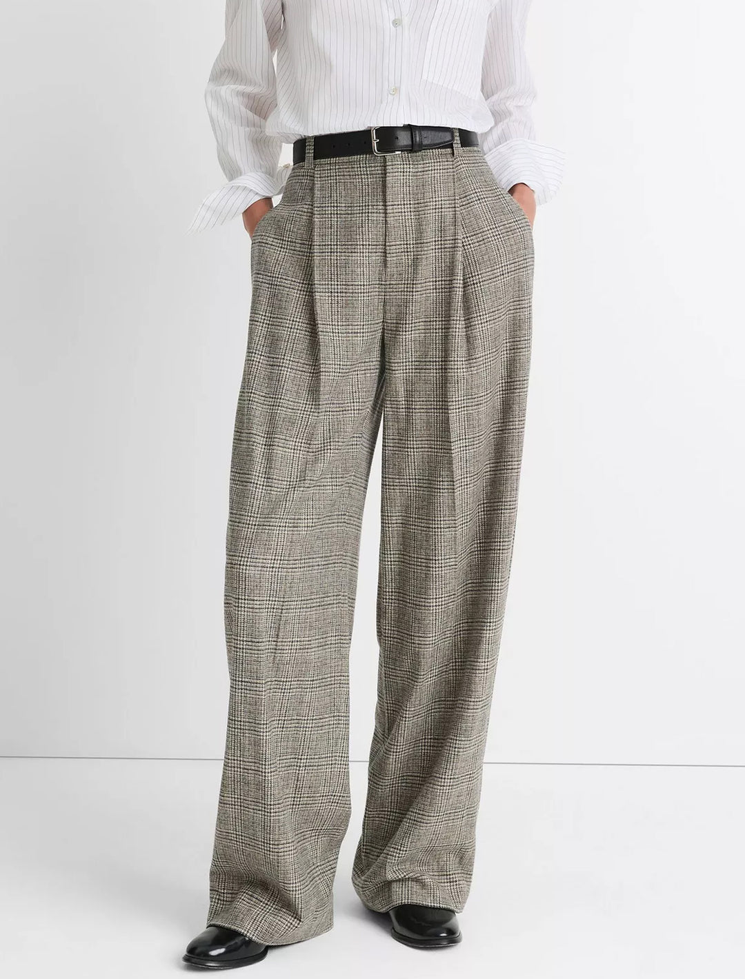 Model wearing Vince's high rise wool blend plaid trouser in heritage plaid.