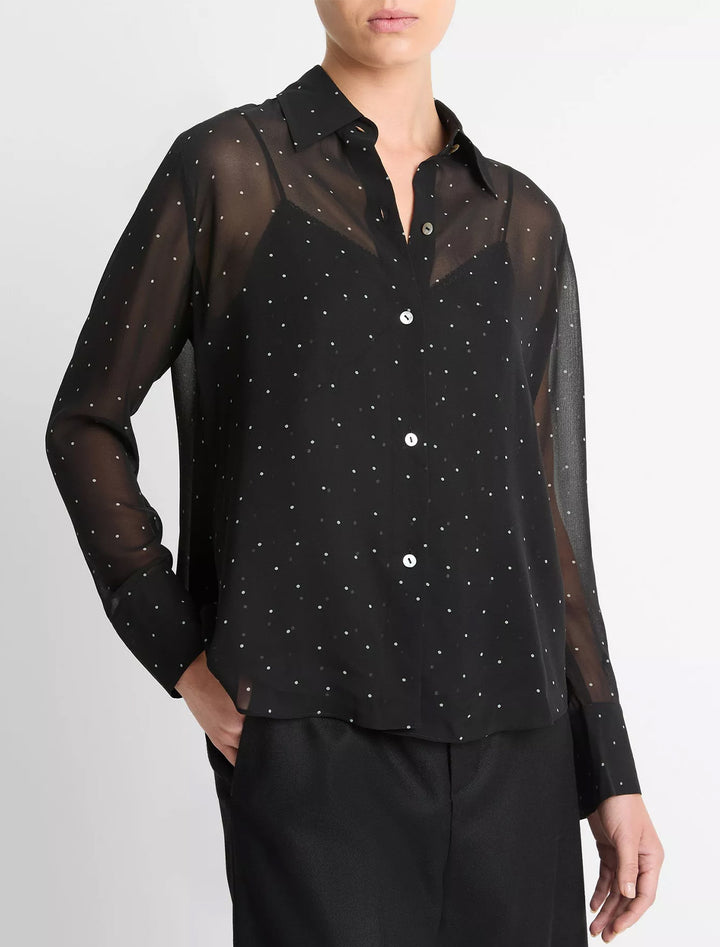 Close-up view of Vince's sheer dot blouse with lace trim cami in black